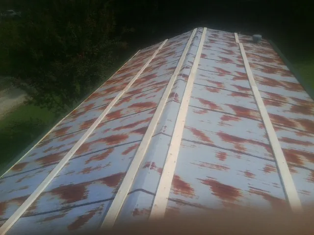 Rusted metal roof panels with new wood purlins before replacement — Storm Damage Roof Repair in Louisville by Roofing Brothers